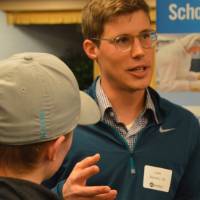 An alumnus talking to students about his field of study at the Academic Major Fair.
